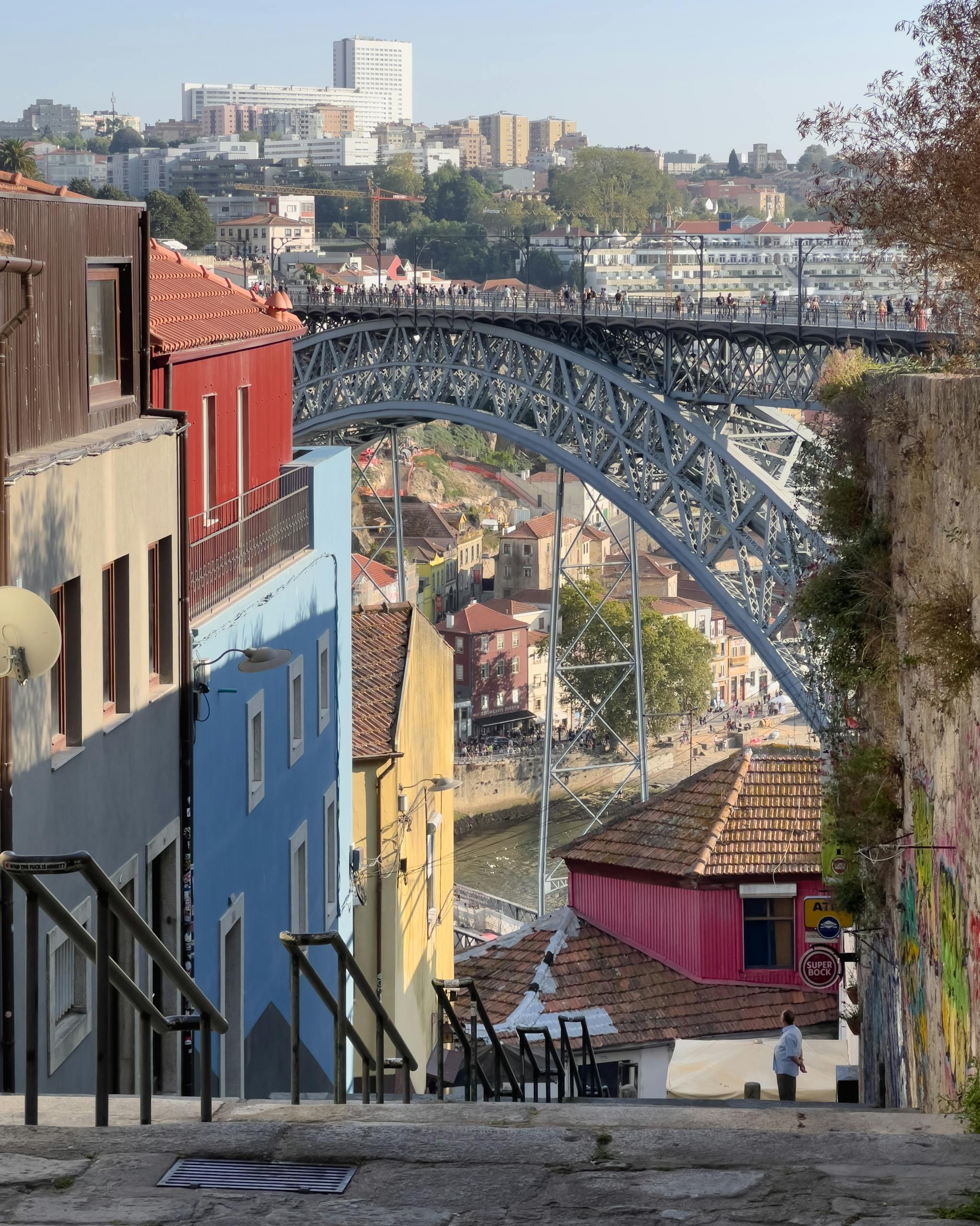 View of Porto's vibrant streets descending to the iconic Luís I Bridge on a sunny day.